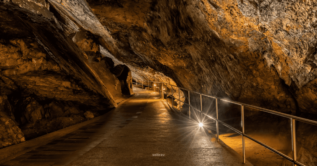 A view inside Aggtelek National Park in Hungary, showcasing illuminated cave pathways with rugged rock formations.
