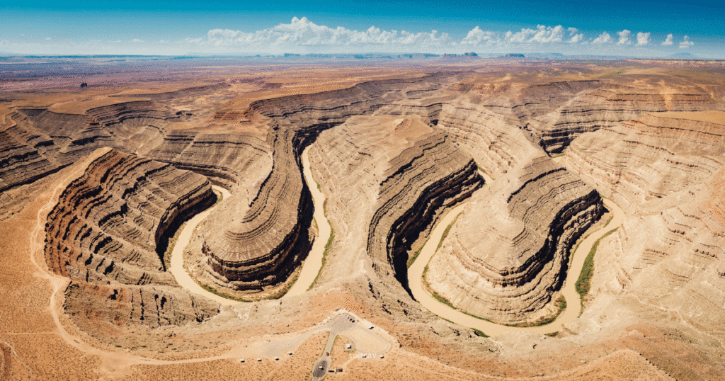 Aerial view of Goosenecks State Park in Utah, showcasing winding canyons and the San Juan River flowing through the landscape.