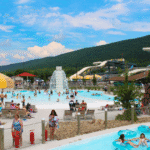 A vibrant water park scene at DelGrosso's Park in Pennsylvania, featuring water slides and a large pool filled with visitors.