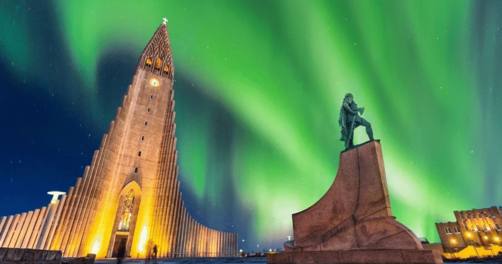 Vibrant Northern Lights illuminate the sky above Hallgrímskirkja church and a statue in Reykjavik, Iceland.